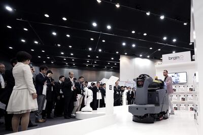 Attendees look at an International Cleaning Equipment (ICE) RS26 rider auto scrubber, powered by Brain Corp.'s Brain OS, during a demonstration at the SoftBank Robot World 2017 in Tokyo, Japan, on Tuesday, Nov. 21, 2017. SoftBank Chief Executive Officer Masayoshi Son has put money into robots, artificial intelligence, microchips and satellites, sketching a vision of the future where a trillion devices are connected to the internet and technology is integrated into humans. Photographer: Kiyoshi Ota/Bloomberg