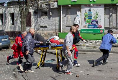 Ukrainian rescuers and medical workers help injured people following a Russian shelling in Kharkiv, Ukraine. EPA