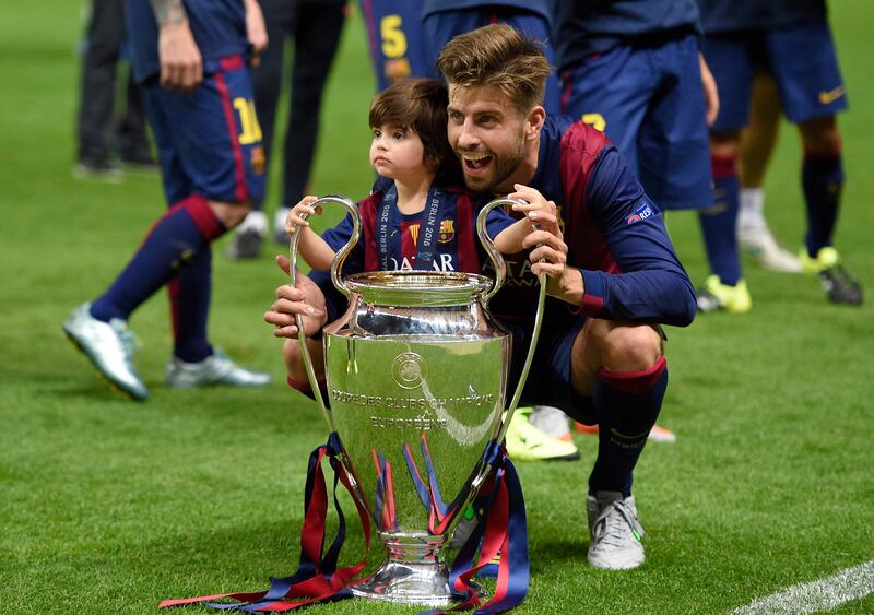 Barcelona's defender Gerard Pique and his son Milan celebrate with the Champions League trophy after their win over Juventus at the Olympic Stadium in Berlin in 2015. AFP