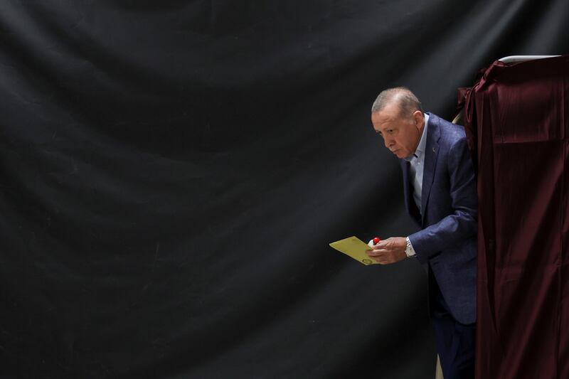 Turkish President Recep Tayyip Erdogan walks out of a voting booth at a polling station in Istanbul, during the country's parliamentary and presidential elections. EPA