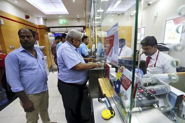 Customers at a UAE Exchange outlet in Dubai prior to the foreign exchange company being placed under supervision by the UAE Central Bank in March this year. Chief executive Bhairav Trivedi said he hopes to have the branches up and running soon after its current takeover deal concludes. Pawan Singh / The National