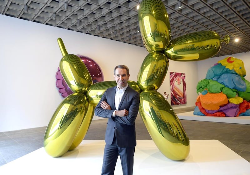 Artist Jeff Koons poses next to one of his sculptures at “eff Koons: A Retrospective, an exhibition of his work at the Whitney Museum of American Art in New York. (AFP / Timothy A. Clary)