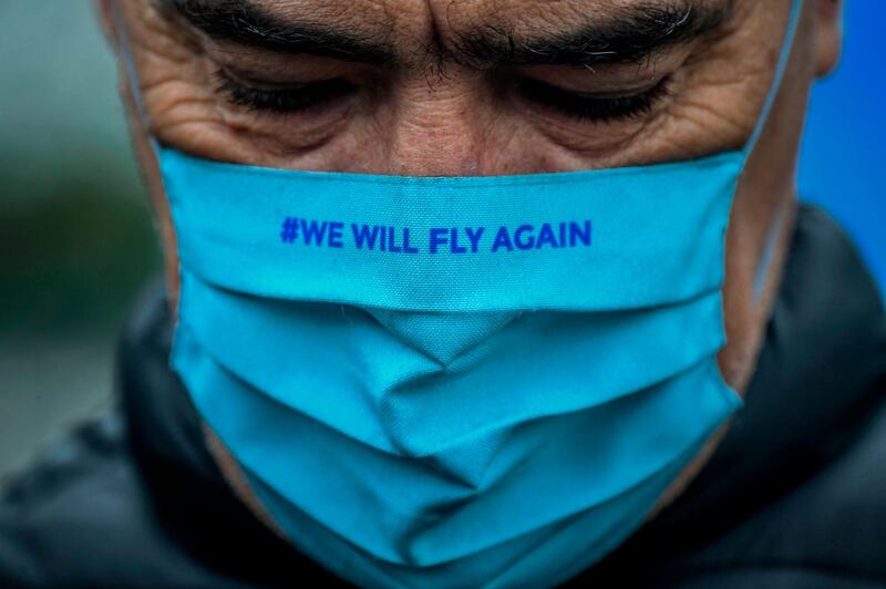 A TAP Air Portugal employee wearing a face mask reading "We will fly again" takes part in a protest against job cuts at TAP airline headquarters in Lisbon. AFP