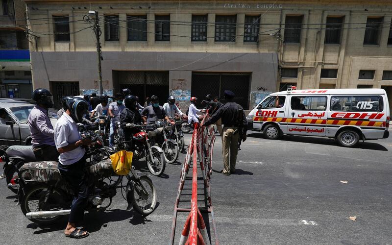 An ambulance moves past barriers, put-up to block road for public transport, during a lockdown in an effort to stop the spread of the coronavirus disease (COVID-19), in a business district of Karachi, Pakistan May 8, 2020. REUTERS/Akhtar Soomro