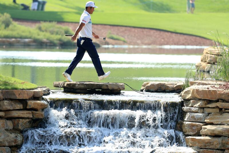 Hideto Tanihara crosses between the 6th and 7th holes during the second round of the DP World Tour Championship. Andrew Redington / Getty Images