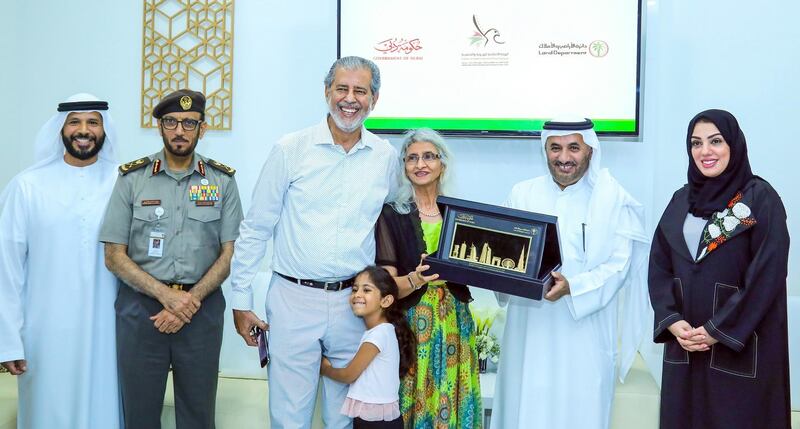 An investor and his family receive the 5-year residency visa in Dubai on Thursday. Courtesy Dubai Land Department