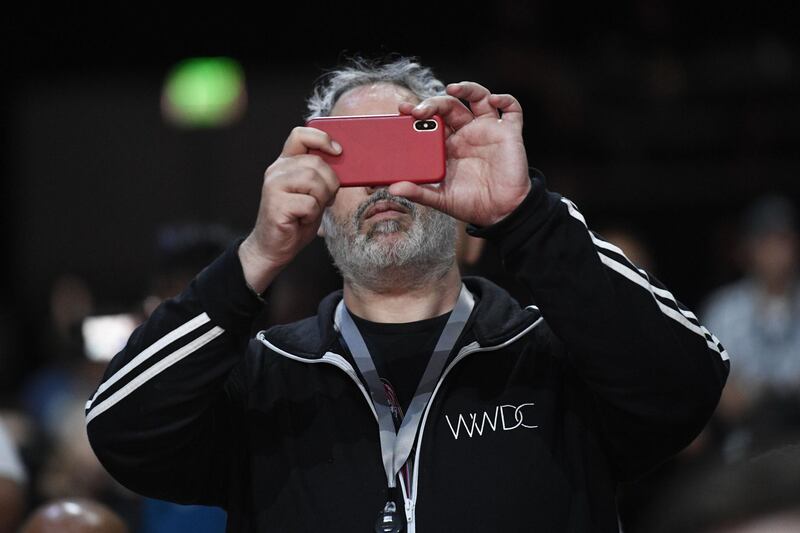 An attendee takes a photograph with an Apple Inc. iPhone X at the Apple Worldwide Developers Conference (WWDC) in San Jose, California, U.S., on Monday, June 4, 2018. Apple Inc. highlighted improvements to its augmented-reality software, a key foundation for iPhones, iPads and future devices. Photographer: David Paul Morris/Bloomberg