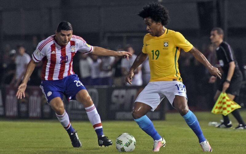 Brazil’s Willian (R) vies for the ball with Paraguay’s Nestor Ortigoza  during their Russia 2018 Fifa World Cup South American Qualifiers’ football match in Asuncion, on March 29, 2016. AFP PHOTO / PABLO BURGOS