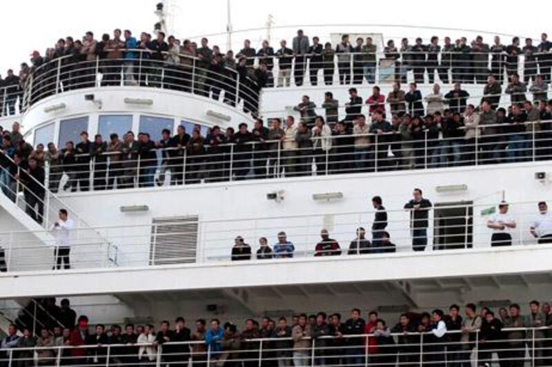 Chinese citizens wait aboard the "Palermo Grimaldi" ferry at the harbor in Valletta, Malta, Saturday, Feb. 26, 2011, after being evacuated from Benghazi, Libya. Tens of thousands of foreigners have been fleeing Libya this week. Turkish and Chinese workers climbed aboard ships by the thousands, Europeans mostly boarded evacuation flights and North Africans have been heading to Libya's borders with Egypt and Tunisia in overcrowded vans. (AP Photo/Gregorio Borgia)