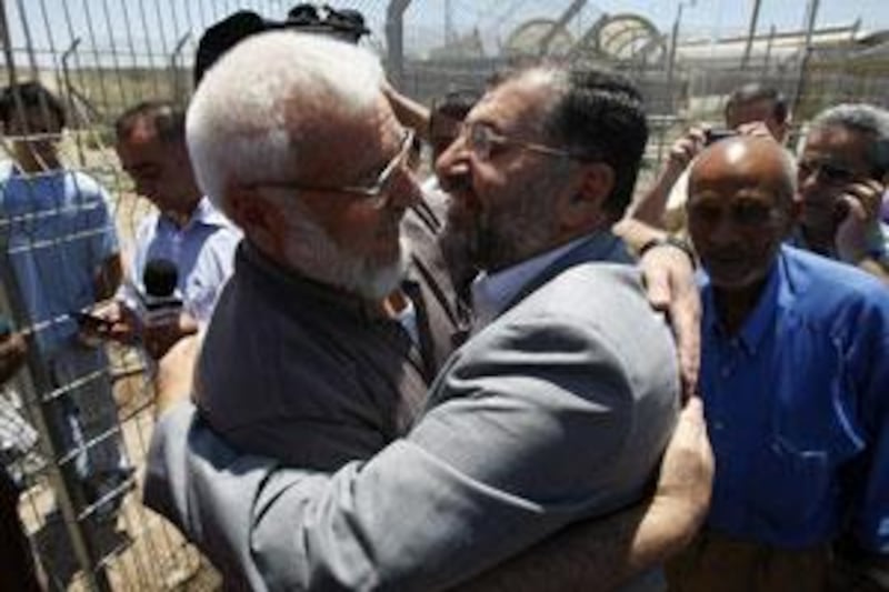 Palestinian parliament speaker Aziz Dweik, left, is greeted by wellwishers after walking through a checkpoint.