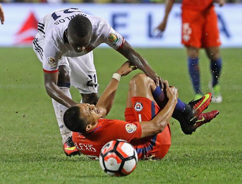 Alexis Sanchez #7 of Chile grabs his leg after being taken down by Marlos Moreno #21 of Colombia during a semi-final match in the 2016 Copa America Centernario at Soldier Field on June 22, 2016 in Chicago, Illinois. Chile defeated Colombia 2-0. Jonathan Daniel/Getty Images/AFP