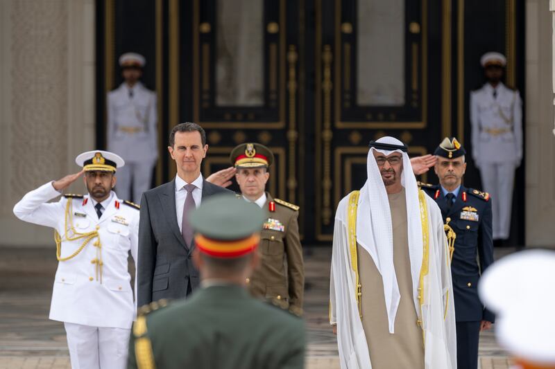 Sheikh Mohamed and Mr Al Assad stand for the national anthem. Presidential Court 