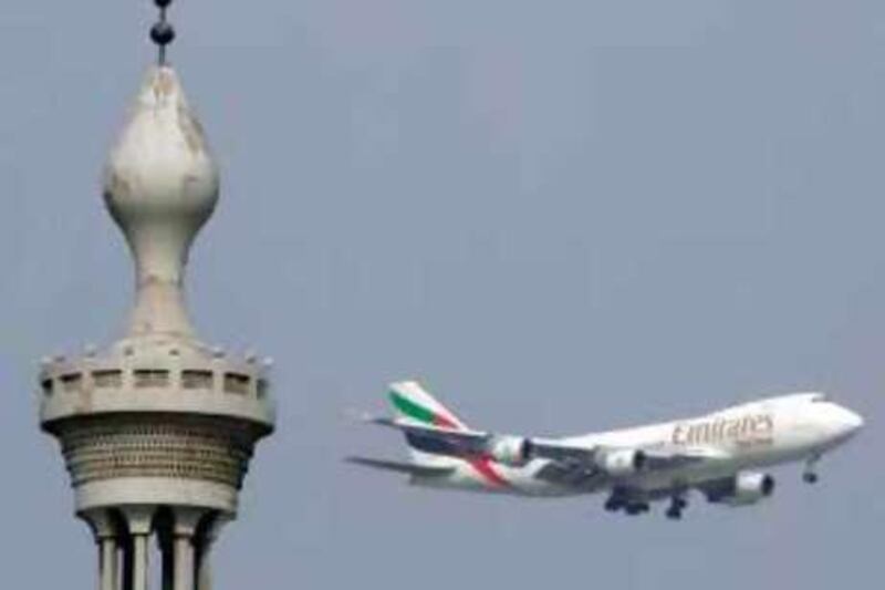 An Emirates Airlines' airplane flies past a minaret 29 December 2006 in the emirate of Dubai. The company vice chairman said he believes that the airline will have too little rather than too much capacity even after its 121 billion Dirhams spent -although the airbus A380 will arrive at Emirates hangars two years late, the airline is optimistic about its expansion plans for 2007. AFP PHOTO/KARIM SAHIB