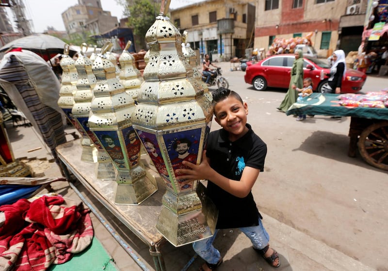 An Egyptian boy carries the traditional decorative lanterns known as 'Fanous' bearing the image of Mohamed Salah, at a market, before the beginning of the holy fasting month of Ramadan in Cairo. Amr Abdallah Dalsh / Reuters