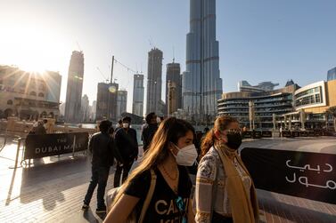 Women walk near The Dubai Mall on January 31. The emirate will cut back capacity in public venues including hotels and shopping centres, but they will remain open. Christopher Pike / Bloomberg