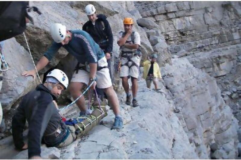Members of the volunteer rescue team assisting Cameron Brooks, 43, after his 10-metre tumble in Wadi Ghalilah on Saturday.