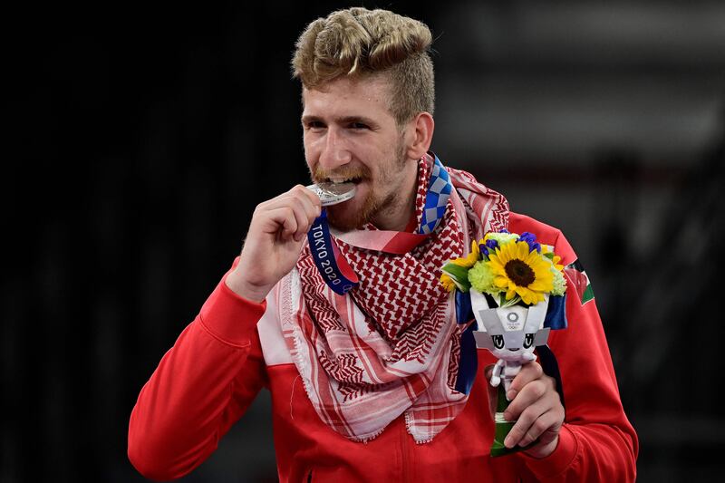 Silver medallist Saleh Elsharabaty of Jordan celebrates on the podium after the taekwondo men's 80kg bouts.