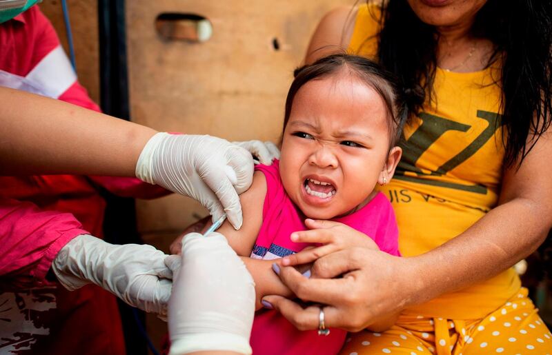 TOPSHOT - A child reacts during a Philippine Read Cross Measles Outbreak Vaccination Response in Baseco compound, a slum area in Manila on February 16, 2019.  A growing measles outbreak in the Philippines killed at least 25 people last month, officials said, putting some of the blame on mistrust stoked by a scare over an anti-dengue fever vaccine. / AFP / Noel CELIS
