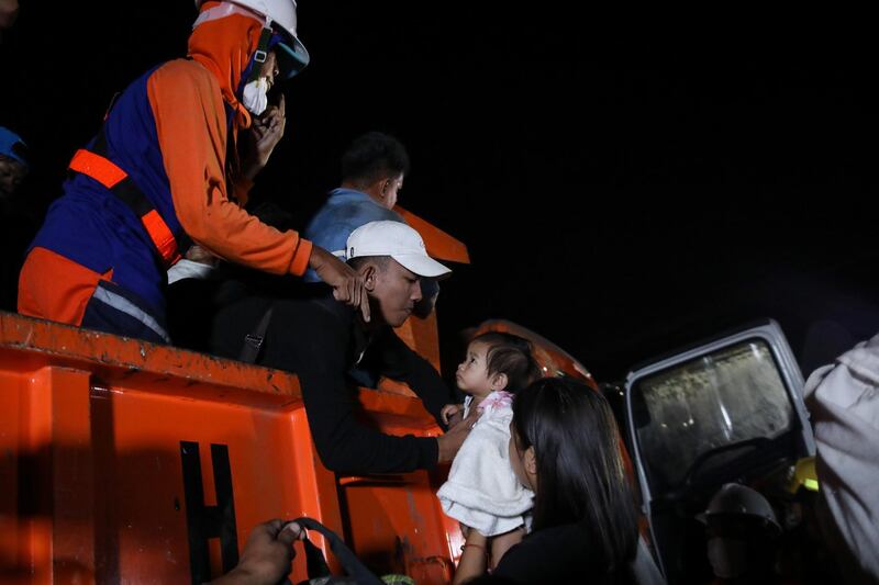 A child is carried onboard a rescue vehicle after a volcano eruption in Talisay, Batangas. EPA