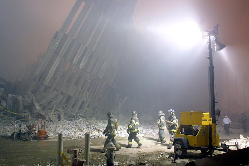Firefighters make their way through the rubble of the World Trade Center 11 September 2001 in New York after two hijacked planes flew into the landmark skyscrapers. AFP PHOTO/Doug KANTER (Photo by DOUG KANTER / AFP)