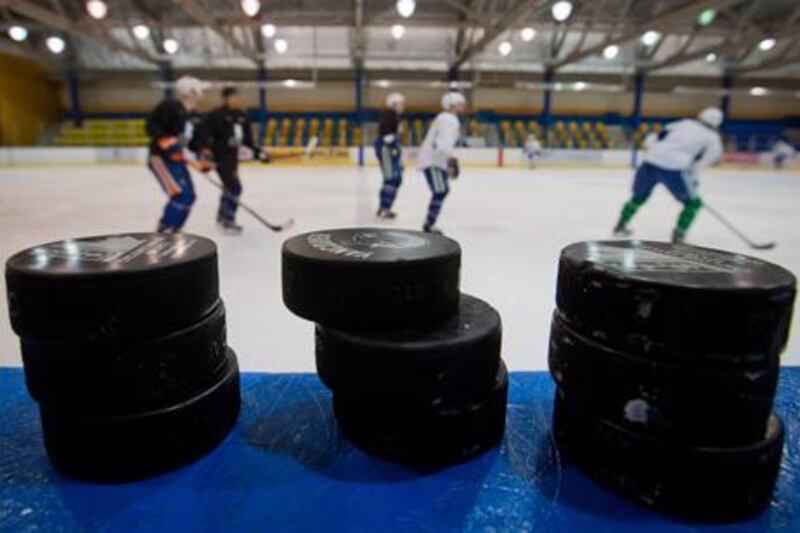 Ice hockey pucks are stacked up as players undergo an informal practice session in Vancouver.