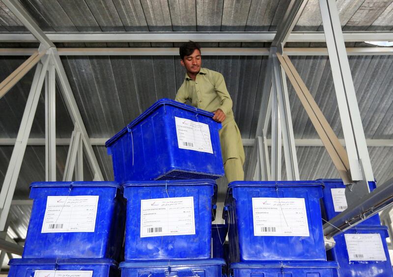 An election commission worker prepares ballot boxes and election material to send to the polling stations at a warehouse in Jalalabad city. Reuters