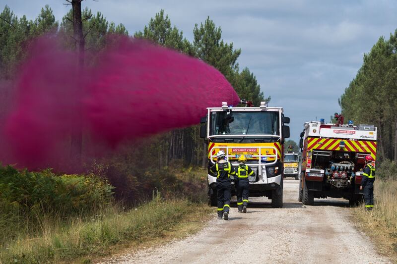 Firefighters spray fire retardant in Le Tuzan. Bloomberg 