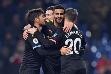 Manchester City's Algerian midfielder Riyad Mahrez (C) celebrates with Manchester City's Spanish midfielder David Silva (L) and Manchester City's Portuguese midfielder Bernardo Silva (R) after scoring their fourth goal during the English Premier League football match between Burnley and Manchester City at Turf Moor in Burnley, north west England on December 3, 2019. Manchester City won the game 4-1. - RESTRICTED TO EDITORIAL USE. No use with unauthorized audio, video, data, fixture lists, club/league logos or 'live' services. Online in-match use limited to 120 images. An additional 40 images may be used in extra time. No video emulation. Social media in-match use limited to 120 images. An additional 40 images may be used in extra time. No use in betting publications, games or single club/league/player publications. / AFP / Paul ELLIS / RESTRICTED TO EDITORIAL USE. No use with unauthorized audio, video, data, fixture lists, club/league logos or 'live' services. Online in-match use limited to 120 images. An additional 40 images may be used in extra time. No video emulation. Social media in-match use limited to 120 images. An additional 40 images may be used in extra time. No use in betting publications, games or single club/league/player publications.