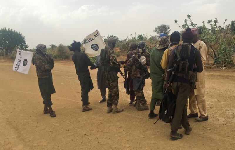 FILE PHOTO: Boko Haram militants (in camouflage) embrace and shake hands with Boko Haram prisoners, released in exchange for a group of 82 Chibok girls, who were held captive for three years by Islamist militants, near Kumshe, Nigeria, May 6, 2017. Picture taken May 6, 2017. REUTERS/Zanah Mustapha/File Photo