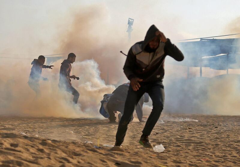 Palestinian protesters flee from tear gas during demonstrations near the border with Israel east of Jabalia in the central Gaza Strip on May 15, 2018 marking 70th anniversary of Nakba -- also known as Day of the Catastrophe in 1948 -- and against the US' relocation of its embassy from Tel Aviv to Jerusalem.  / AFP / MOHAMMED ABED
