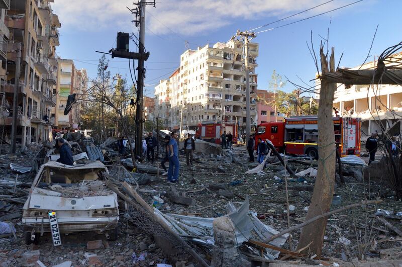 People watch the damage after an explosion in southeastern Turkish city of Diyarbakir, early Friday, Nov. 4, 2016. A large explosion hit the largest city in Turkey's mainly Kurdish southeast region on Friday, wounding several people, the state-run Anadolu Agency reported. The cause of the explosion was not immediately known but Hurriyet newspaper said it may have been caused by a car bomb. (IHA via AP)