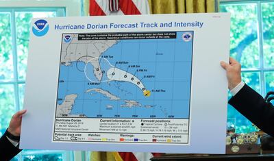 U.S. President Donald Trump and acting DHS Secretary Kevin McAleenan hold up a National Oceanographic and Atmospheric Administration (NOAA) chart showing the original projected track of Hurricane Dorian that appears to have been extended with a black line to include parts of the Florida panhandle and of the state of Alabama during a status report meeting on the hurricane in the Oval Office of the White House in Washington, U.S., September 4, 2019. REUTERS/Jonathan Ernst