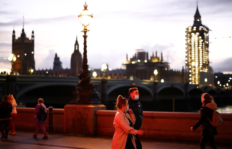 The Houses of Parliament can be seen as people walk along the South Bank in London. Reuters