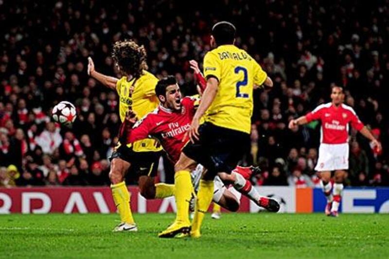 Fabregas, centre, was hurt in winning a penalty in a challenge from Barca's Carles Puyol.