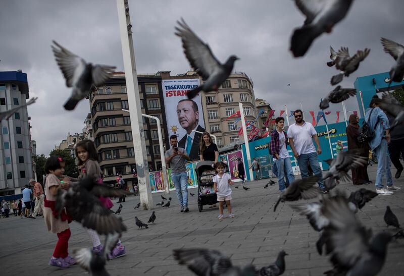 epa06841847 People walk in front of the poster of Turkish President Recep Tayyip Erdogan which reads, 'Thank you Istanbul' at Taksim Square in Istanbul, Turkey, 26 June 2018.  Turkish Electoral Commission on 26 June announced Recep Tayyip Erdogan has won the presidential elections. In the parliamentary elections, which were held at the same time as the presidential elections, although the Justice and Development Party (AKP) won with 42.5 percent of the votes, it lost the absolute majority which the party had secured in the parliament since 2002.  EPA/SEDAT SUNA