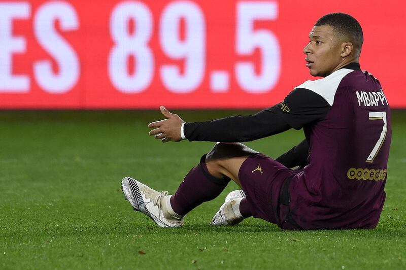Paris Saint-Germain's French forward Kylian Mbappe reacts as he sits on the pitch. AFP