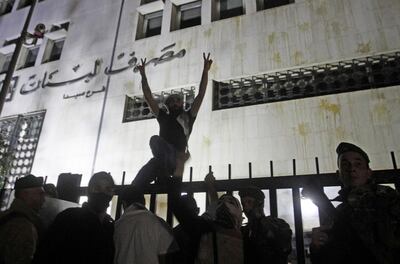 Lebanese anti-government protesters rally over the country's deteriorating economy in front of the central bank headquarters in the southern city of Sidon (Saida) on April 27, 2020. Lebanon is facing its worst economic crisis since the 1975-1990 civil war, now compounded by a nationwide lockdown to stem the spread of the coronavirus. The Lebanese pound has lost more than half of its value, and prices have soared. / AFP / Mahmoud ZAYYAT
