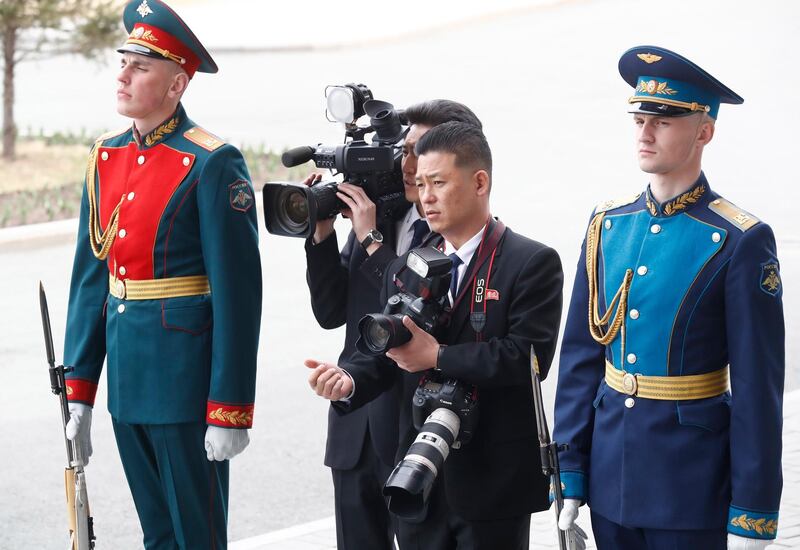 North Korean journalists stand between honor guards. EPA