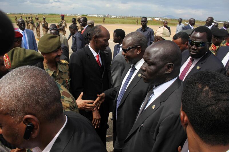 South Sudan's ex-vice president and former rebel leader Riek Machar, centre, shakes hands with military officers as he arrives at the Juba international airport for discussion with the government on the formation of a unity governmentat, in Juba, South Sudan. REUTERS