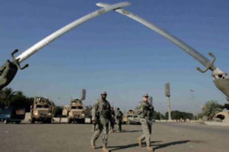 US Army soldiers walk under the "crossed swords" monument in the US-protected Green Zone in Baghdad.