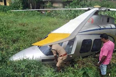 Local police officials check a helicopter carrying UAE retail tycoon Yusuff Ali that made an emergency landing on Sunday in an empty field in Kochi, in southern Indian Kerala state . Courtesy Malayalam Manorama