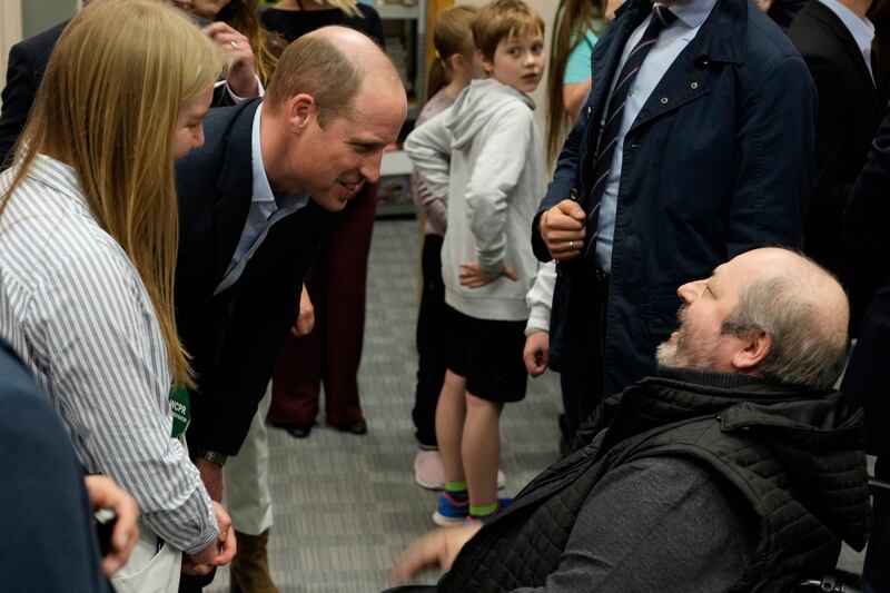 Prince William speaks to a man as he visits an accommodation centre in Warsaw for Ukrainians who fled the war. AP