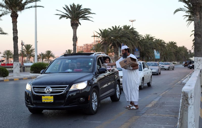 A Libyan man distributes snacks and water to motorists to breaking their fast in Tripol.   AFP