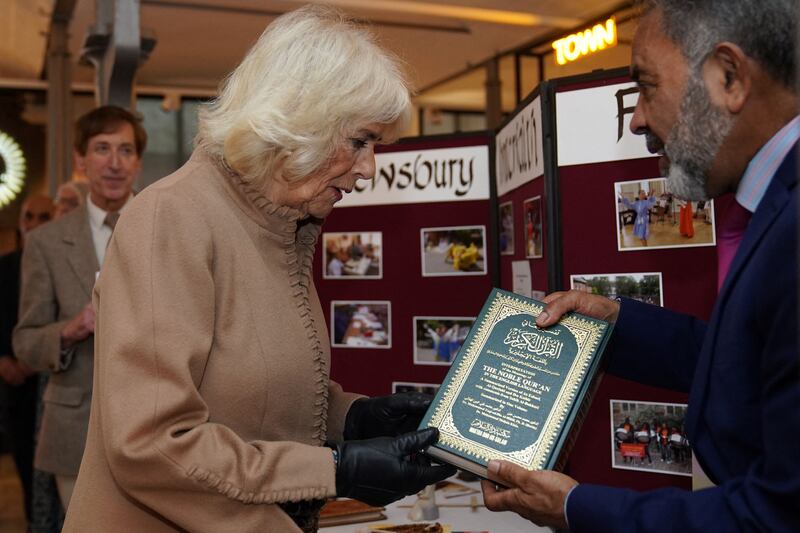 Queen Camilla receives a copy of the Quran from John Mustafa during a visit to Shrewsbury in England. AFP