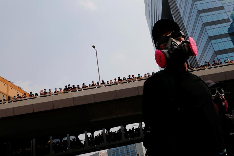 An anti-extradition bill protester looks at police during a march to demand democracy and political reforms, at Kowloon bay, Hong Kong. Reuters
