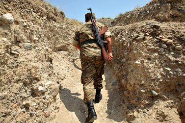 An Armenian soldier of the self-proclaimed republic of Nagorno-Karabagh walks in a trench at the frontline on the border with Azerbaijan near the town of Martakert on July 11, 2012. AFP  