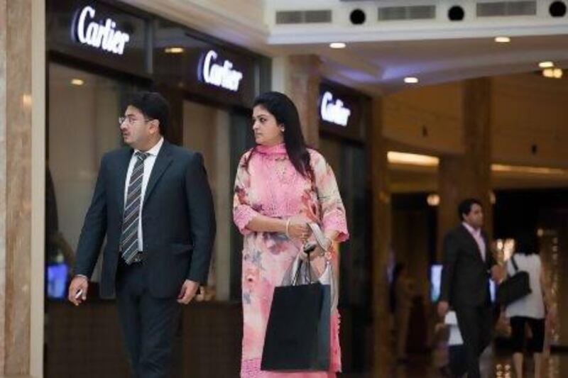 People walk past a Cartier store at the DLF Emporio shopping mall in New Delhi.