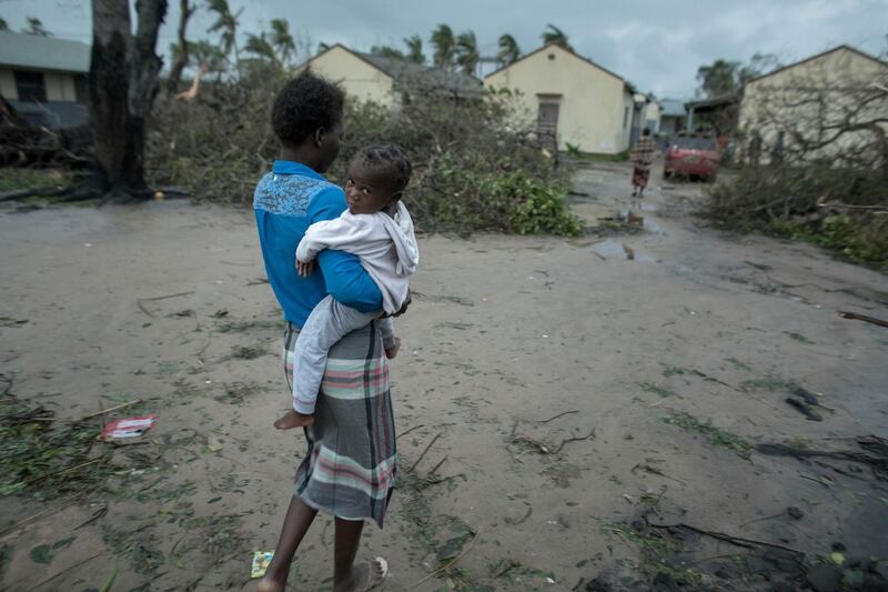 A woman and child near a school building being used as emergency shelter for some 300 local people who are unable to return to their homes following cyclone force winds and heavy rain in the coastal city of Beira, Mozambique. CARE via AP