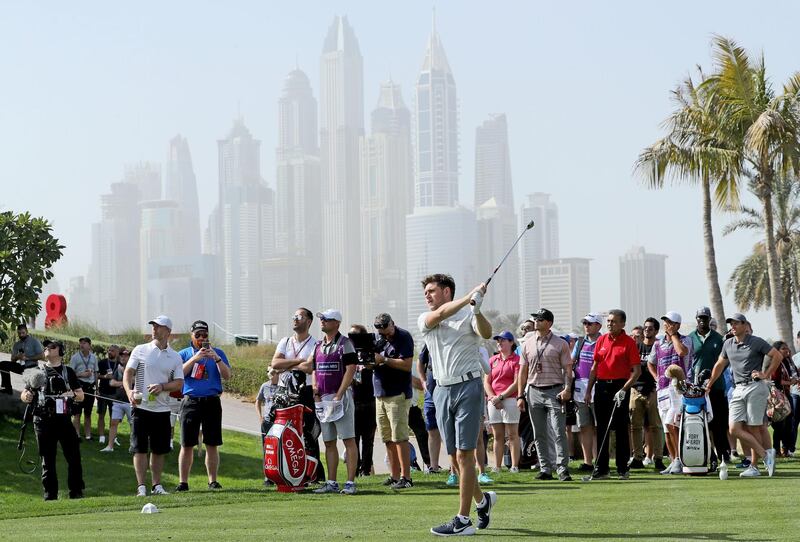 Niall Horan plays a shot watched by Rory McIlroy during the pro-am as a preview for the Omega Dubai Desert Classic on the Majlis Course at Emirates Golf Club in Dubai. David Cannon / Getty Images