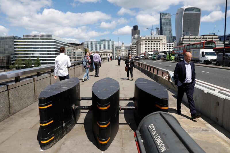 (FILES) This file photo taken on June 07, 2017 shows pedestrians walking through newly installed barriers on the pavement on London Bridge in London.
Barriers, sandbags and concrete lions are among the preventive measures deployed in European city centres in the wake of a spate of vehicular terror attacks across the continent over the past year. / AFP PHOTO / Odd ANDERSEN